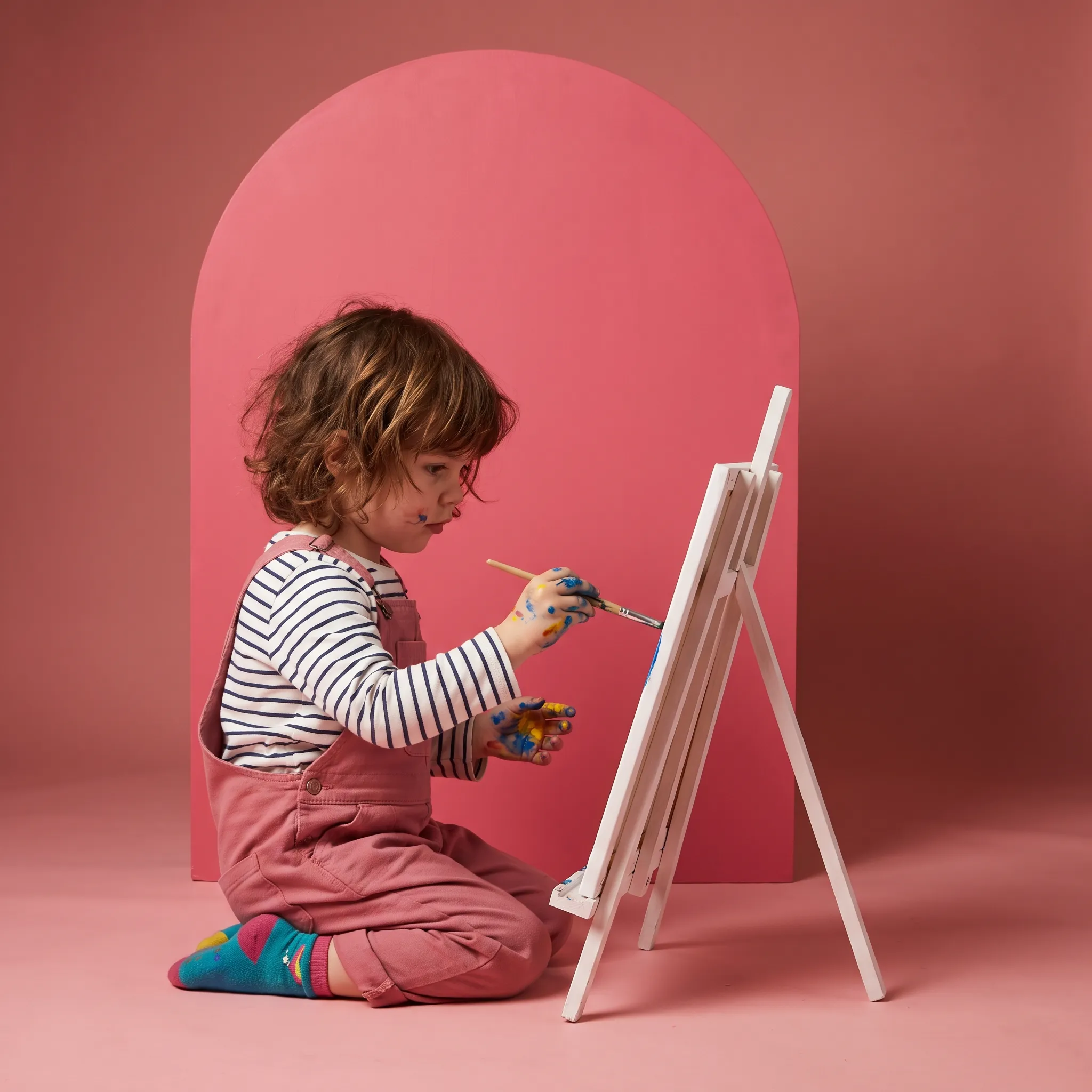 A child painting at a small easel